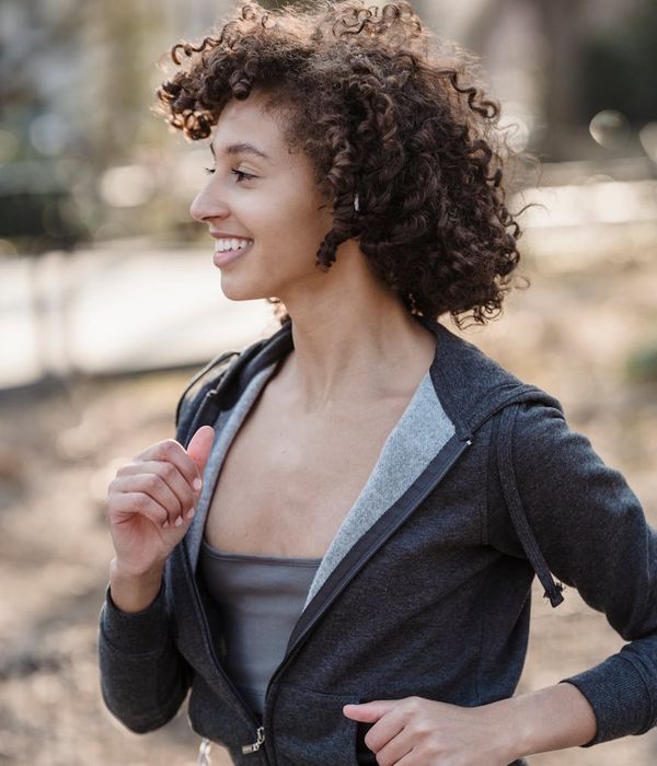 Woman feeling energetic and happy during her morning cardio routine in a bright room.